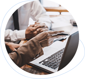 two business people’s hands next to a silver laptop