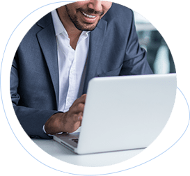 a smiling businessman looking at a silver laptop