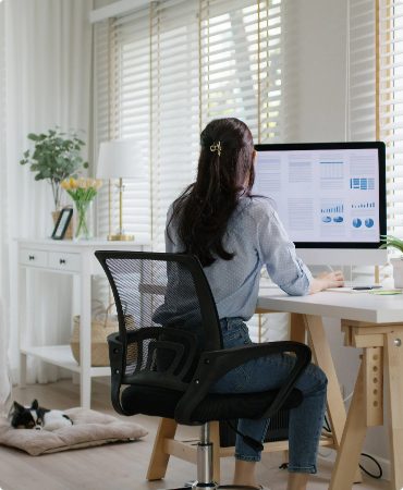 Back View of Woman Seated while looking at Computer Screen.
