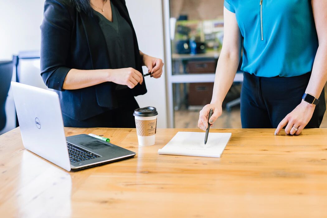 Two people standing in front of a desk