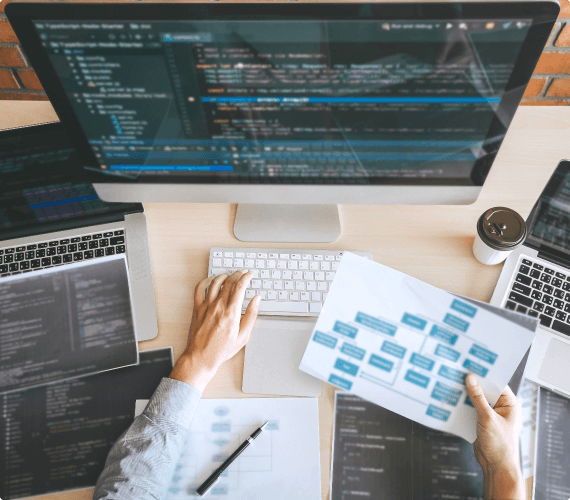 Multiple Computer Screens and Keyboards Showing Coding Information
