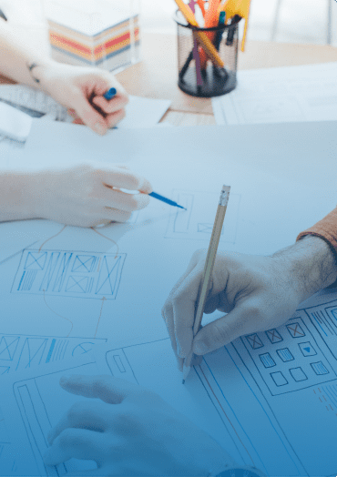 Hands drafting a design for a website