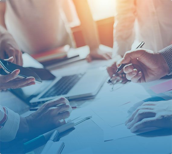 people crowded around a busy office desk