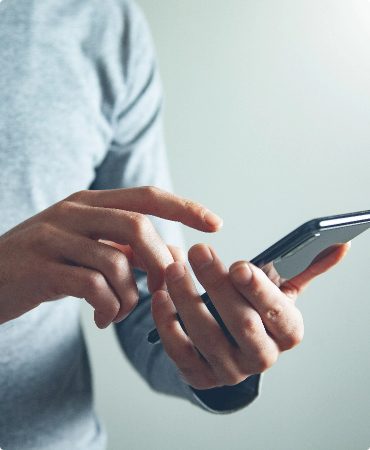 Man holding a mobile device in his left hand