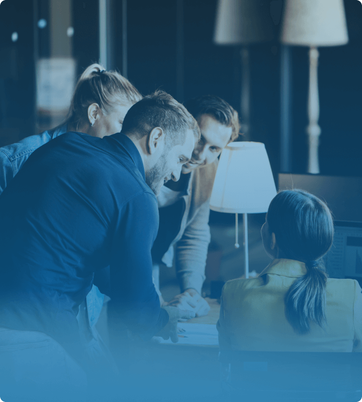 SaaS team collaborating around a desk discussing scaling strategies and digital transformation