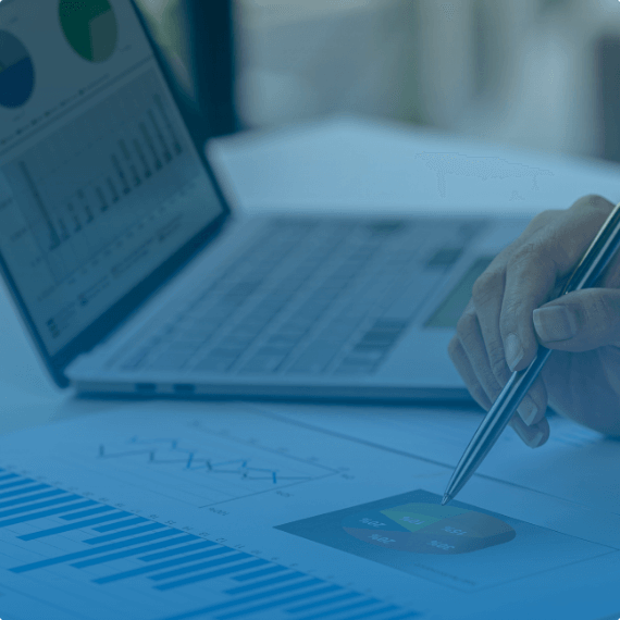 hand holding a pen above charts