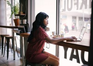 woman typing on a laptop in a cafe