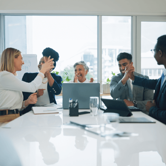 group of people working on a laptop against a window