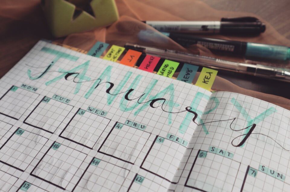A calendar planner lying open on a desk