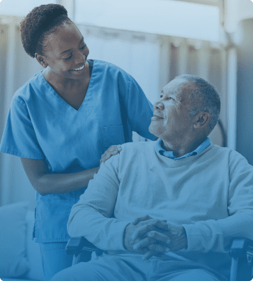 Healthcare SEO Image: A nurse in scrubs smiling warmly at an elderly man seated in a wheelchair, set in a healthcare environment.