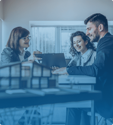 Real Estate SEO Image: A real estate agent presenting documents to clients in an office setting with a miniature house model on the table.