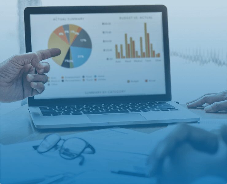 hand pointing at charts on a laptop