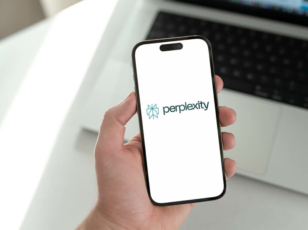 hand holding a mobile device displaying the Perplexity logo