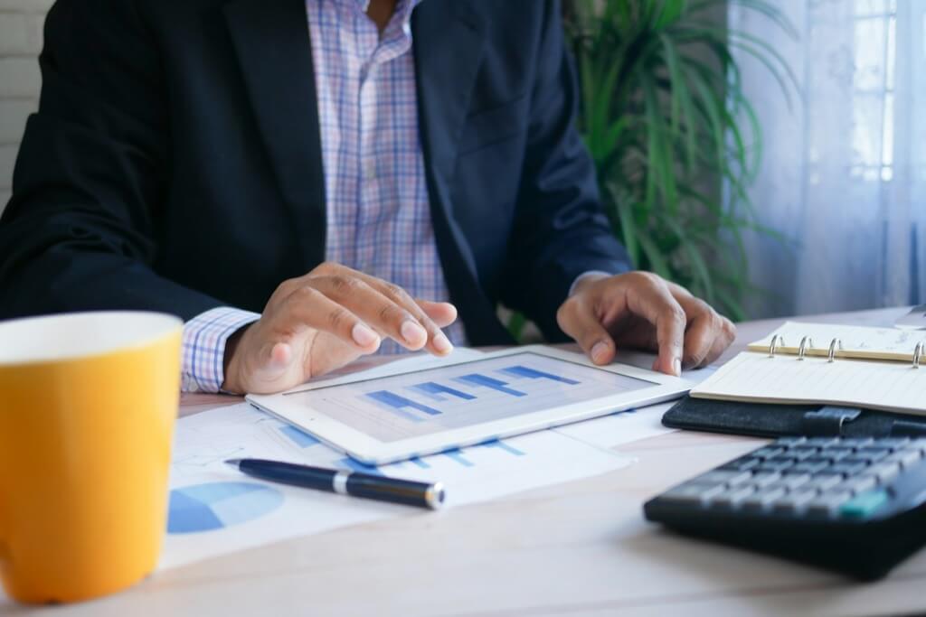 a person in a black suit working at a desk
