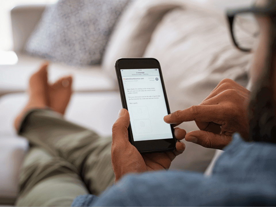 A person using a smartphone while sitting on a couch.
