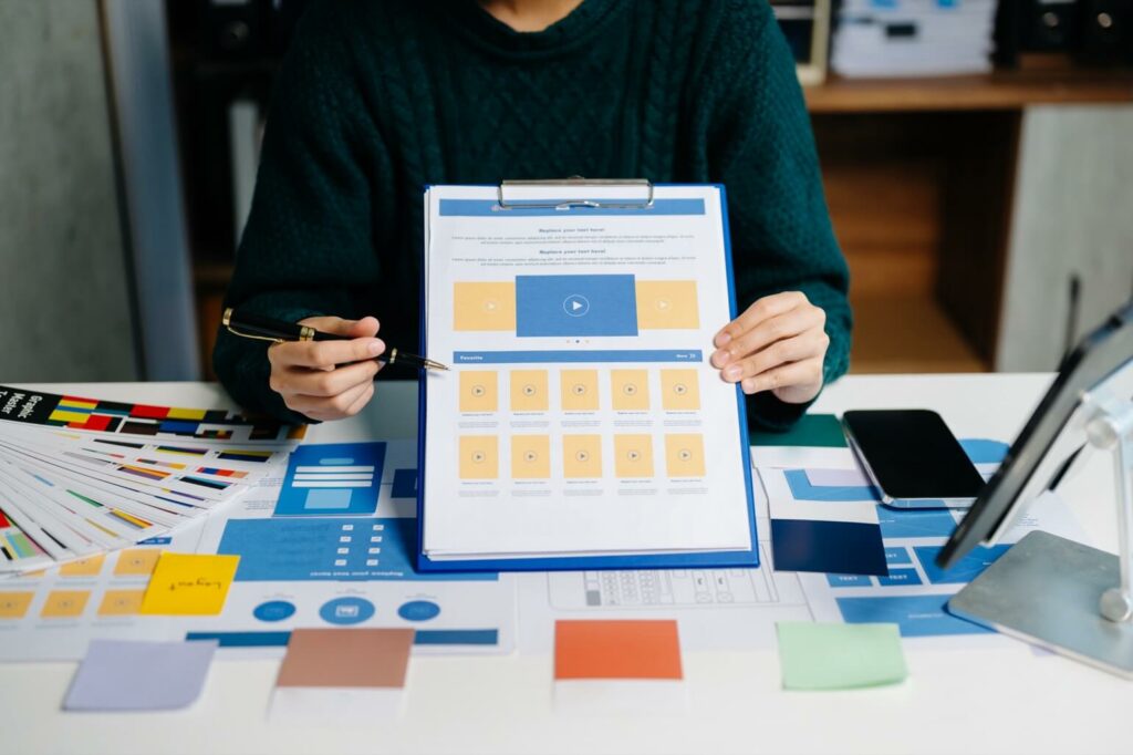 person holding a clipboard with a website mockup