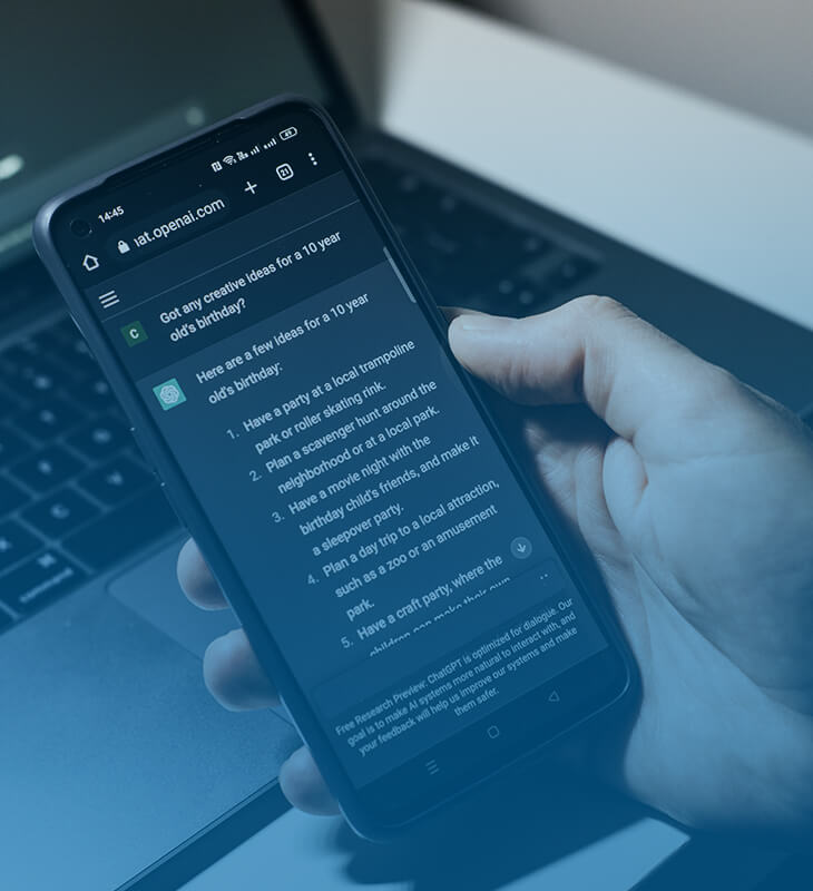 hand holding a mobile device with a chatbot