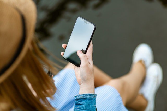 a woman in a striped skirt holding a cellphone